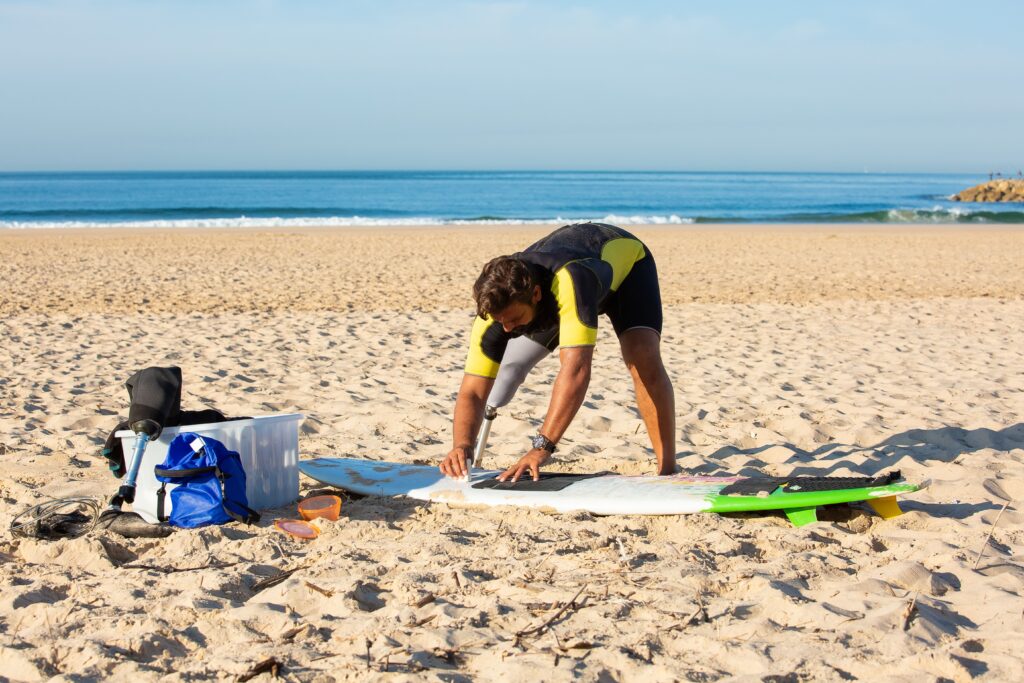 Surfista preparando su tabla antes de entrar al mar en Margarita